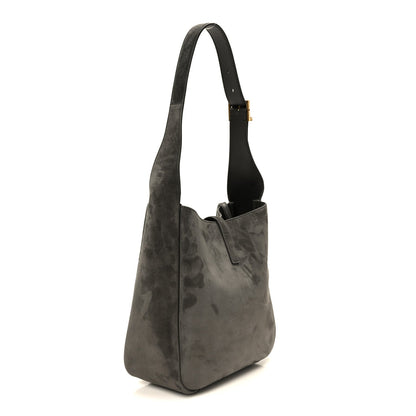 Grey suede hobo bag with top handle, vertical seam, and gold-toned hardware