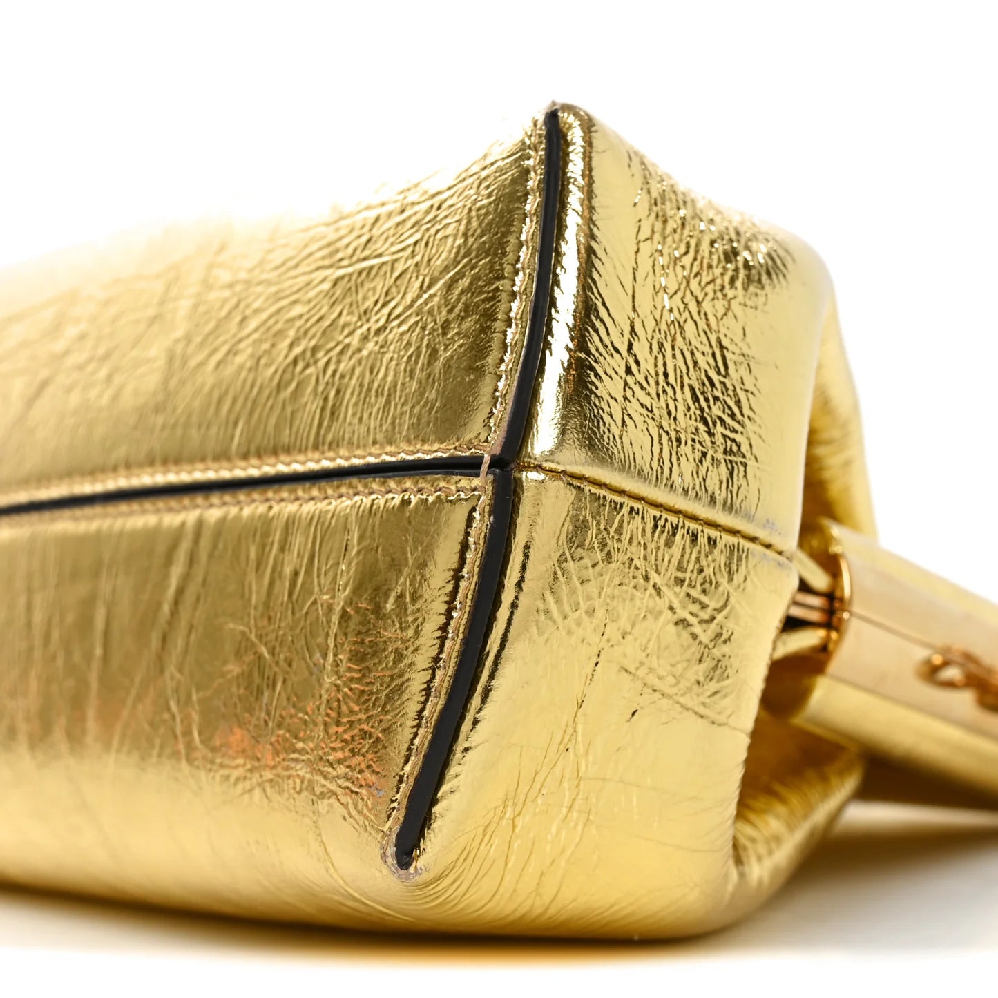 Metallic gold leather bag close-up of front panel and strap connection