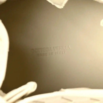 Bottega Veneta logo stamp inside a light cream woven bag