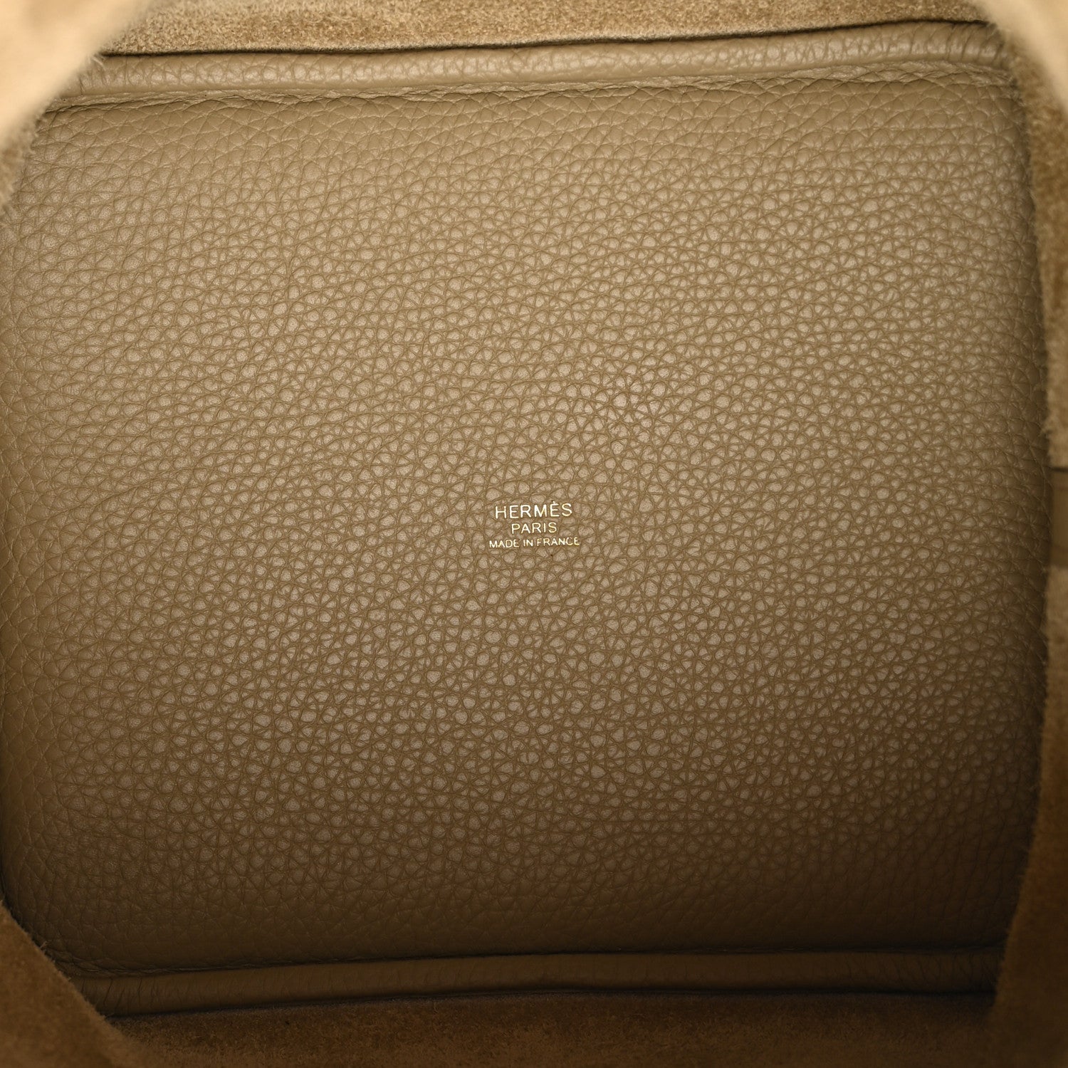 Beige leather tote interior with embossed brand text and stitched trim