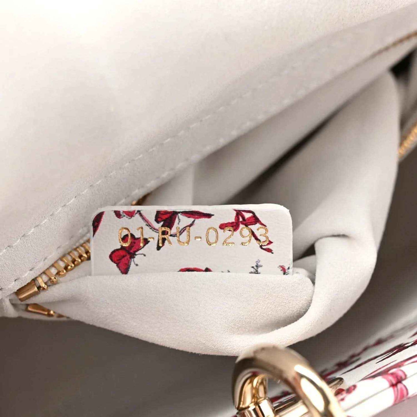 Handbag interior view with floral pocket lining and gold zipper hardware