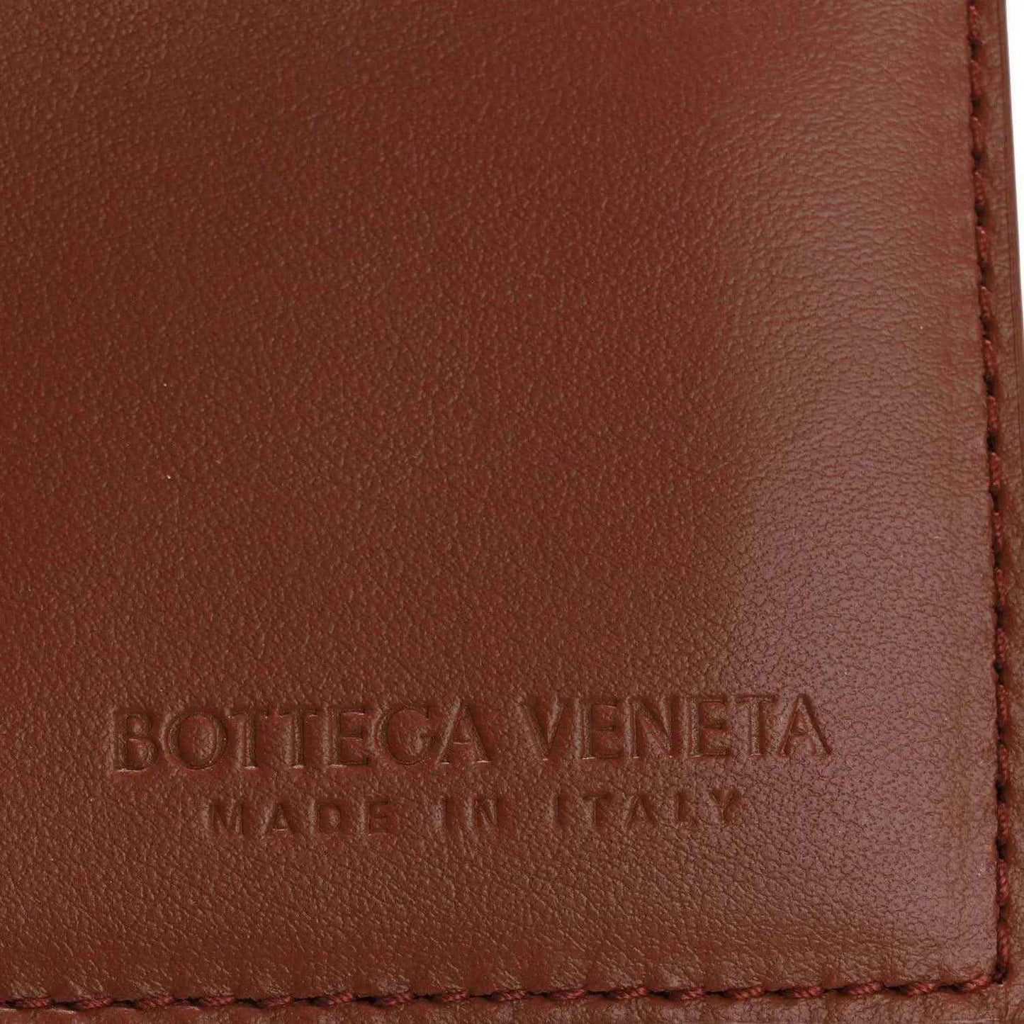 Bottega Veneta stamped leather panel with red-stitched edge on brown flap.