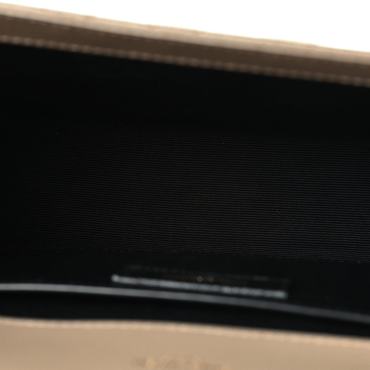 Black leather interior label with gold text, partially visible