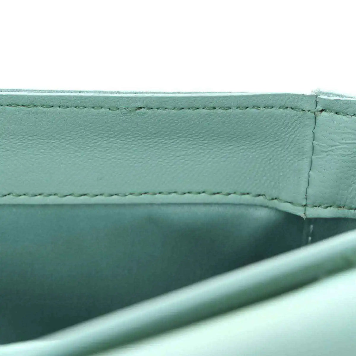 Light blue satin nappa baguette bag, side seam and interior panel close-up