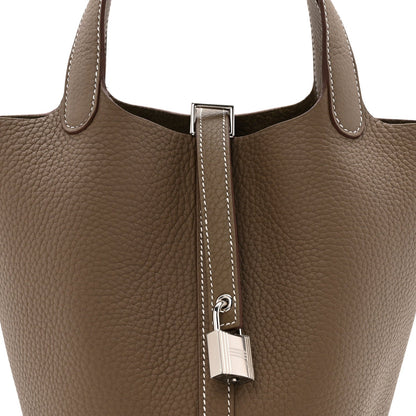 Etoupe leather tote with lock clasp and contrast-stitched strap detail