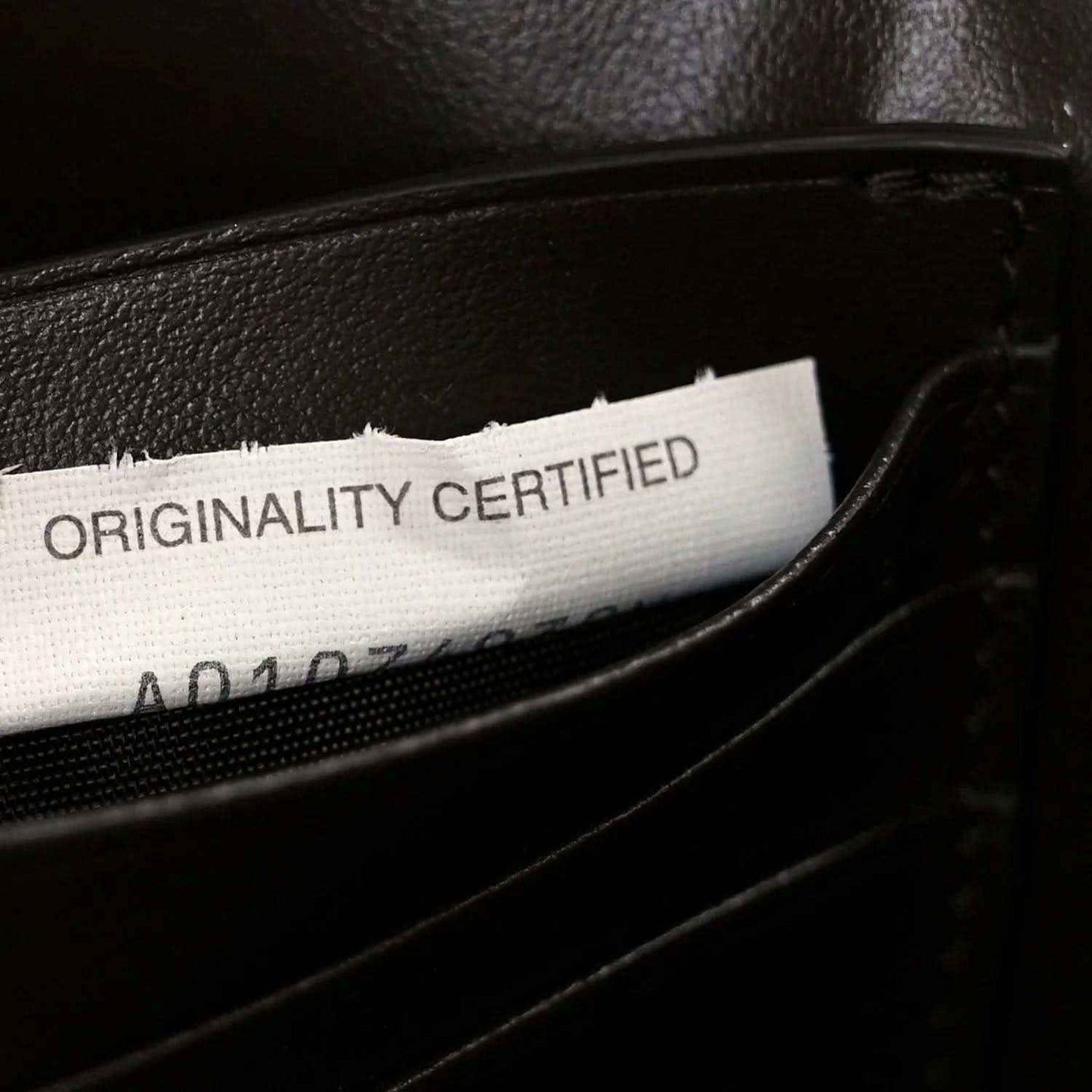 Originality Certified label inside dark leather clutch