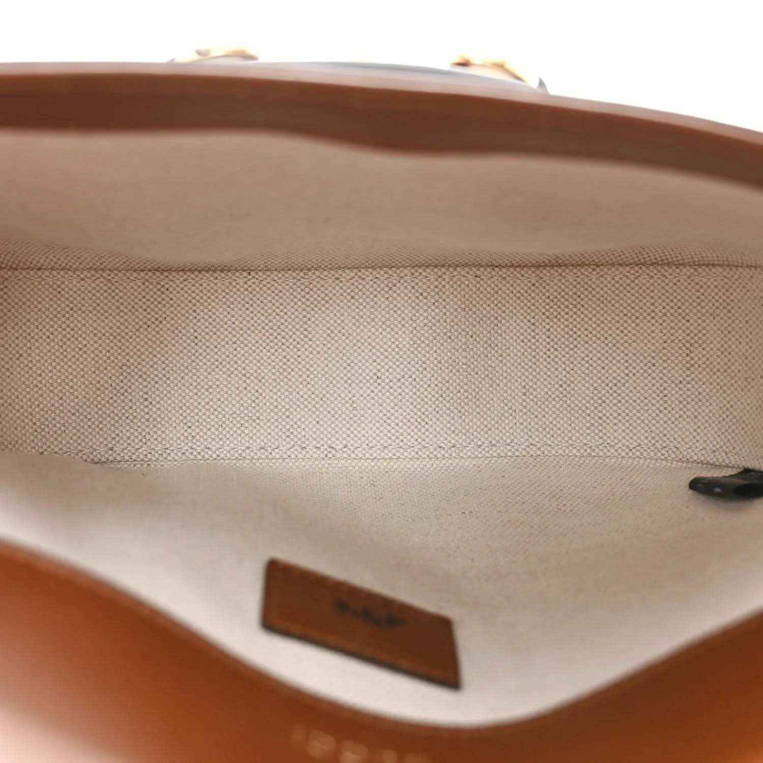 Leather-lined mini bag interior with stitched edge and brown brand patch