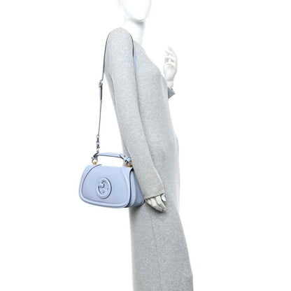 Light blue Gucci top-handle bag with detachable shoulder strap, shown on a mannequin