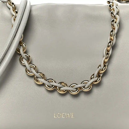 Loewe clutch chain strap detail with interlinked metal links on light grey leather