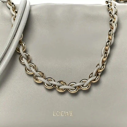 Loewe clutch chain strap detail with interlinked metal links on light grey leather