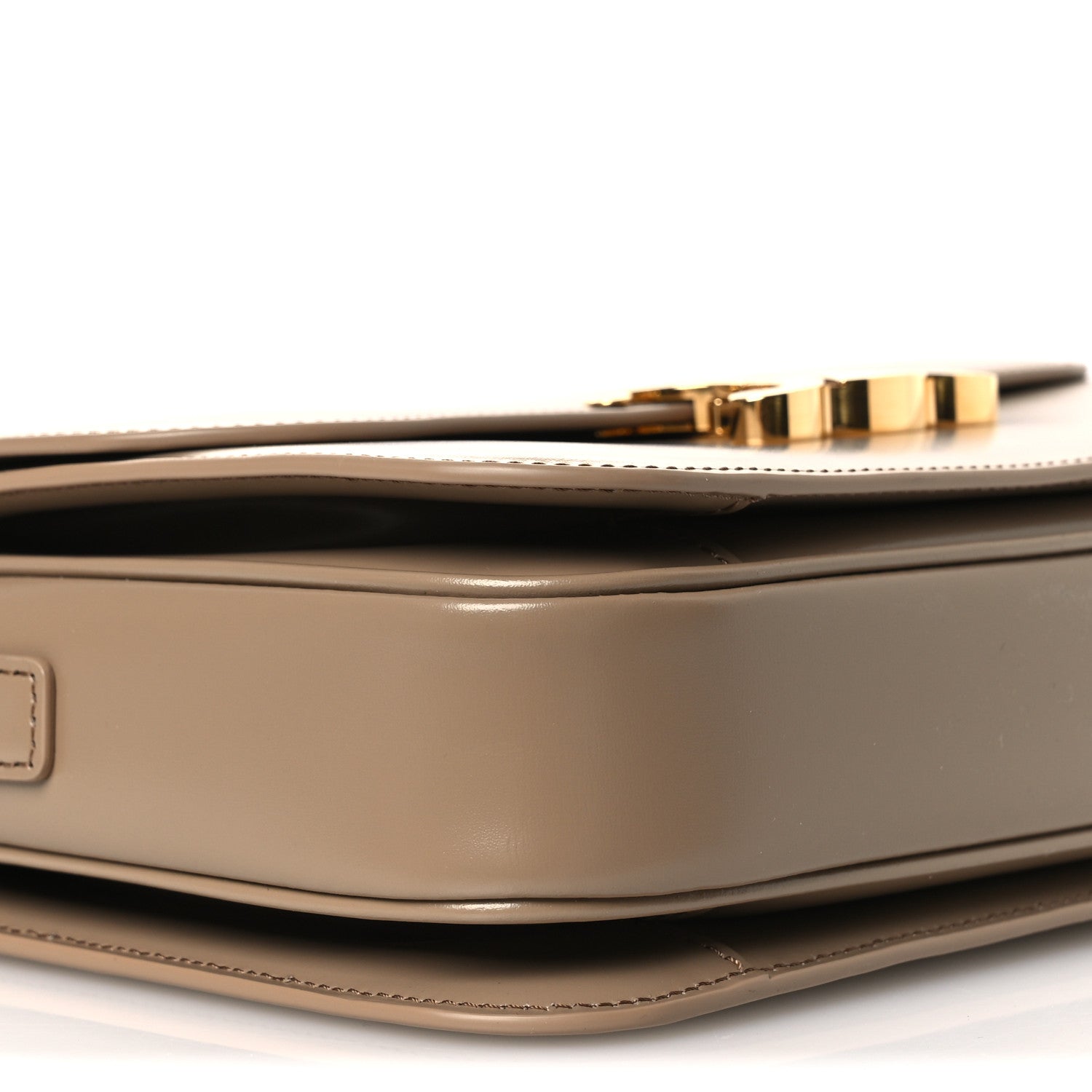 Shiny brown leather shoulder bag with gold-tone top trim and curved flap edge