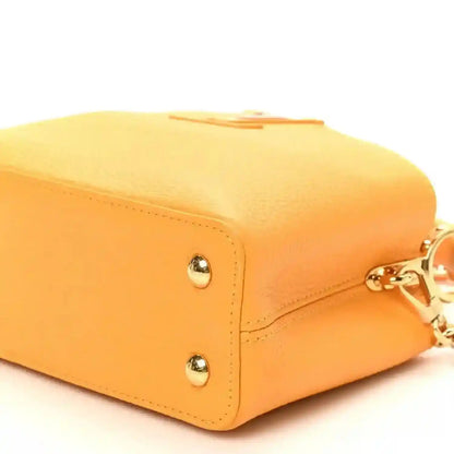 Mini Capucines handbag in yellow textured leather with corner stud detail and stitched edge