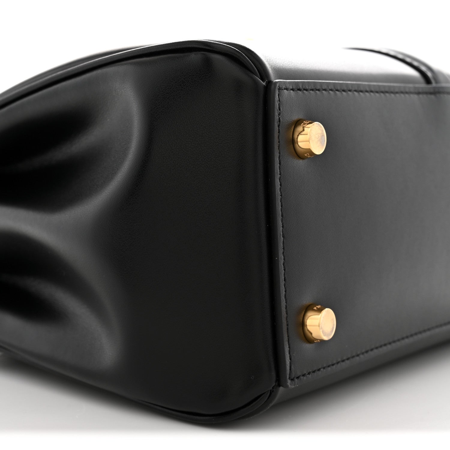 Black leather side panel with gold snap studs and sculpted bag corner