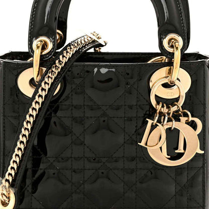 Black patent quilted mini Lady Dior handbag with gold top rings and dangling charm