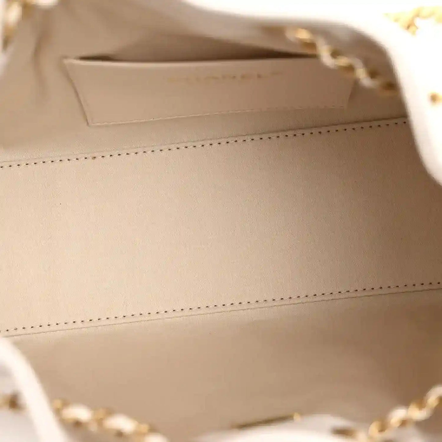 White leather interior of a mini handbag with stitched lining seams