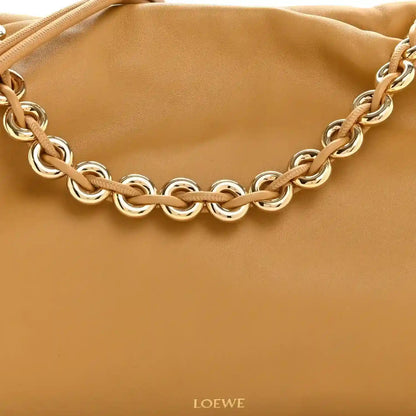 Tan leather clutch with braided chain strap and gold-tone metal links