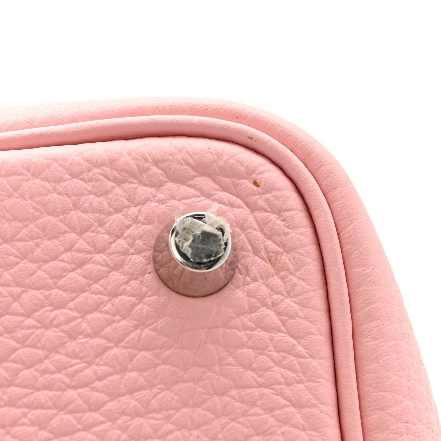 Rose pink leather handbag with round metal snap button on the side