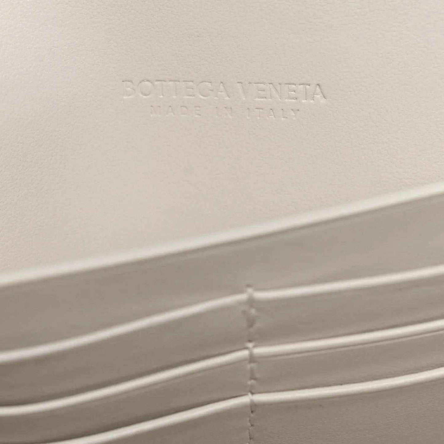 White Bottega Veneta leather clutch interior with embossed logo