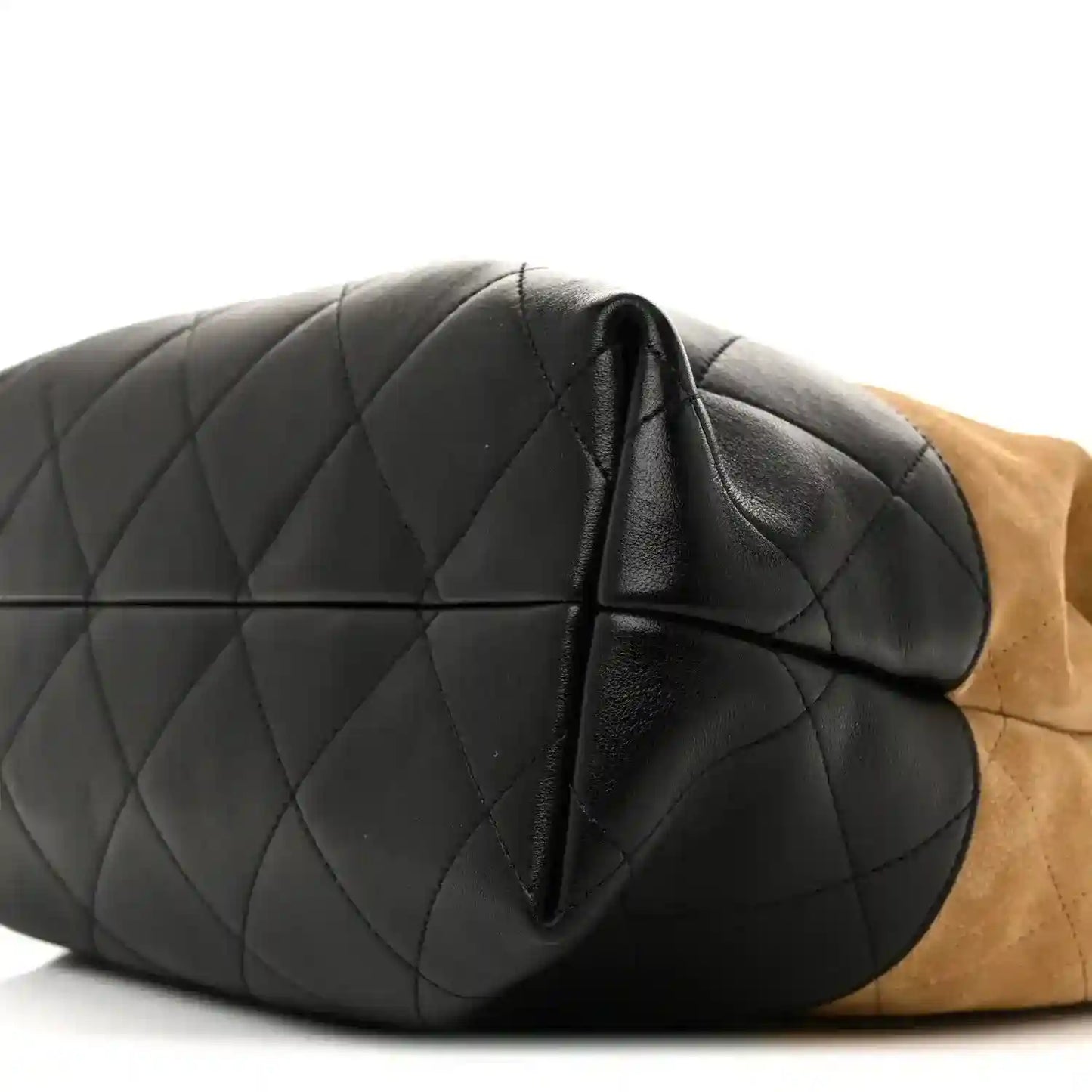 Chanel quilted black shopping bag close-up with curved seam and black leather panel