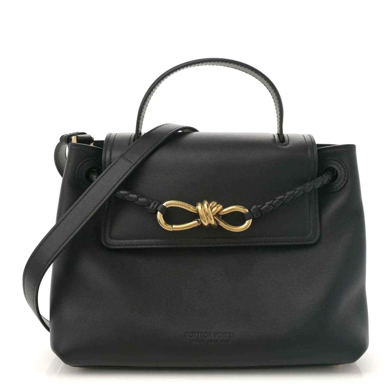 Black leather small shoulder bag with top handle, crossbody strap, and gold bow clasp.