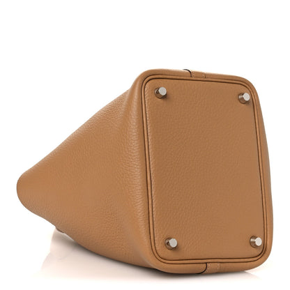 Tan textured leather bucket bag with silver lock studs and rounded side profile.