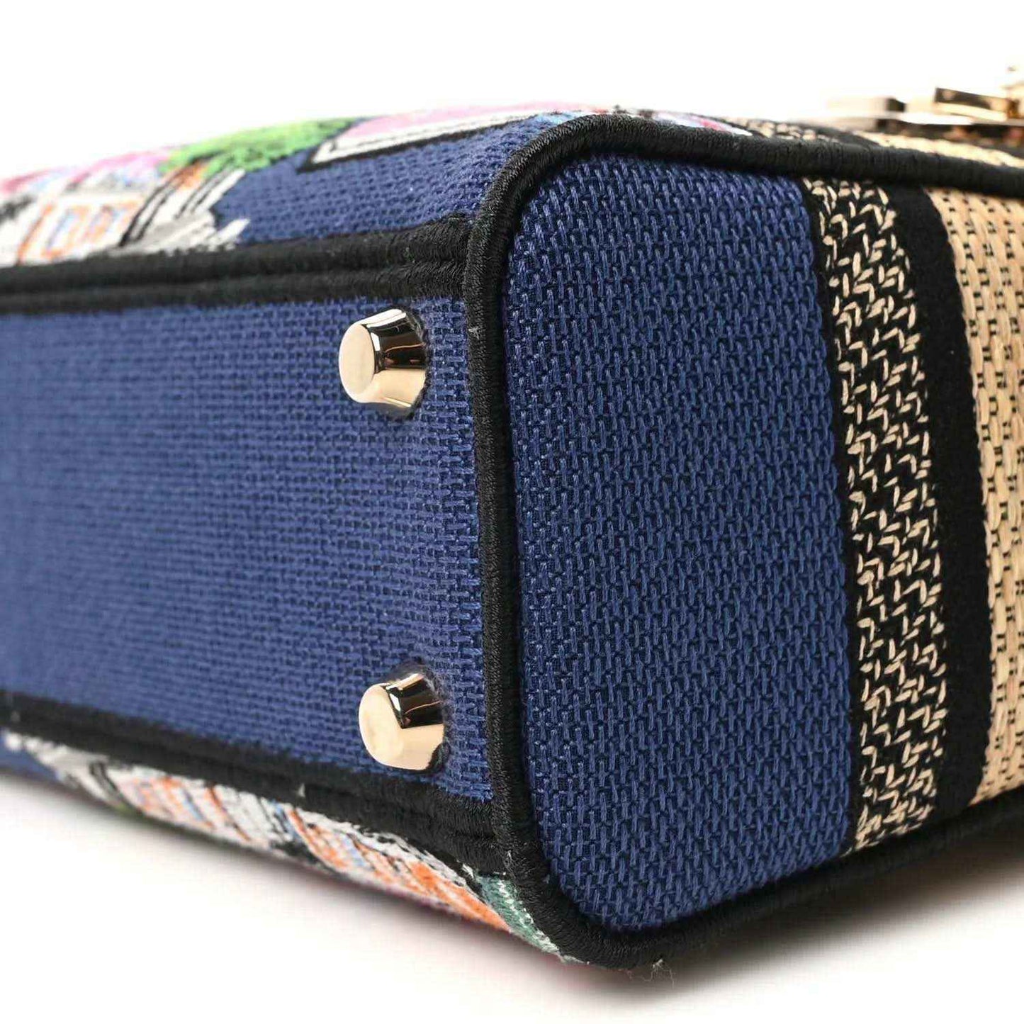 Blue handbag end panel with gold screw studs and embroidered woven trim