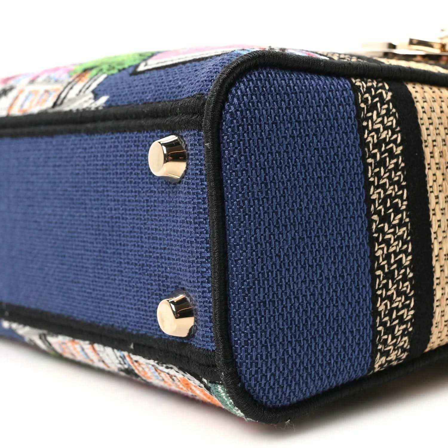 Blue handbag end panel with gold screw studs and embroidered woven trim