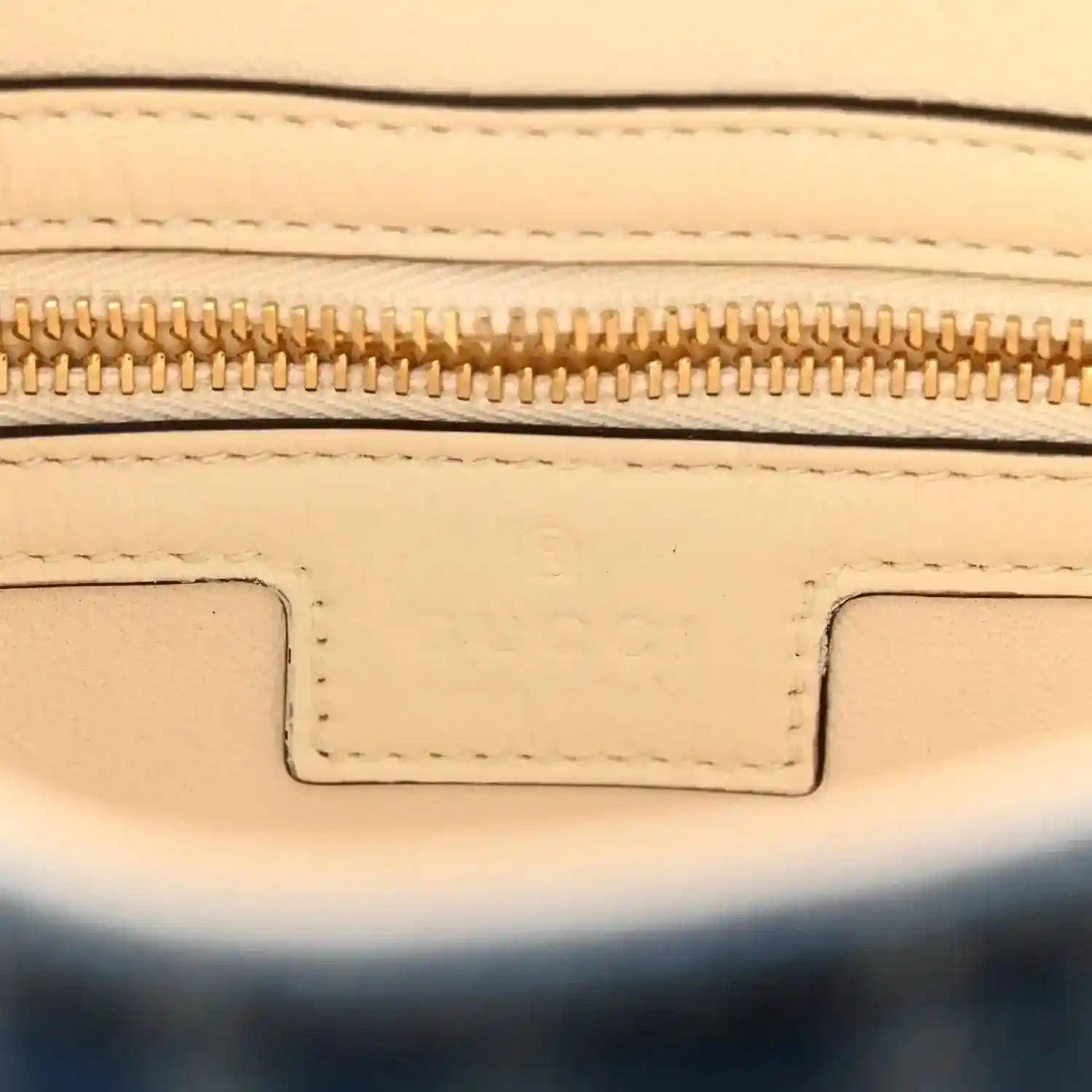 Beige leather interior edge with gold zipper and stitched trim