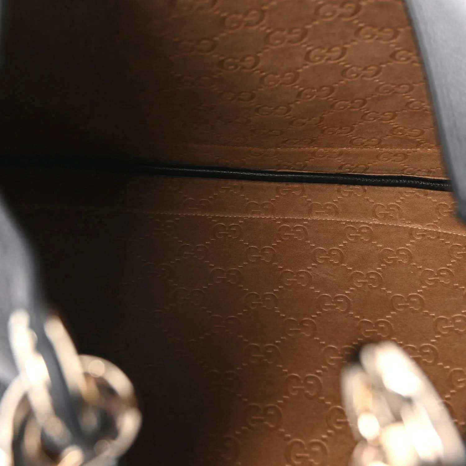 Brown logo-pattern leather interior panel with black zipper trim