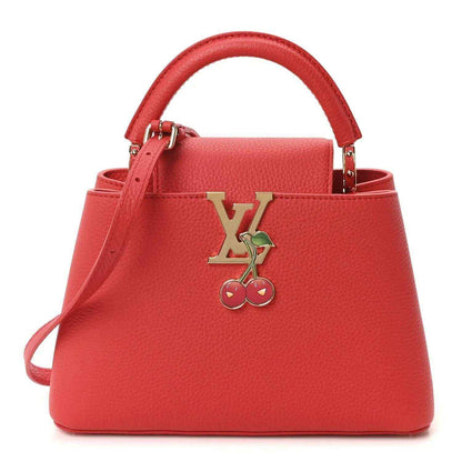 Red leather mini handbag with top handles and gold cherry LV charm centerpiece.