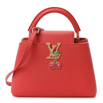 Red leather mini handbag with top handles and gold cherry LV charm centerpiece.