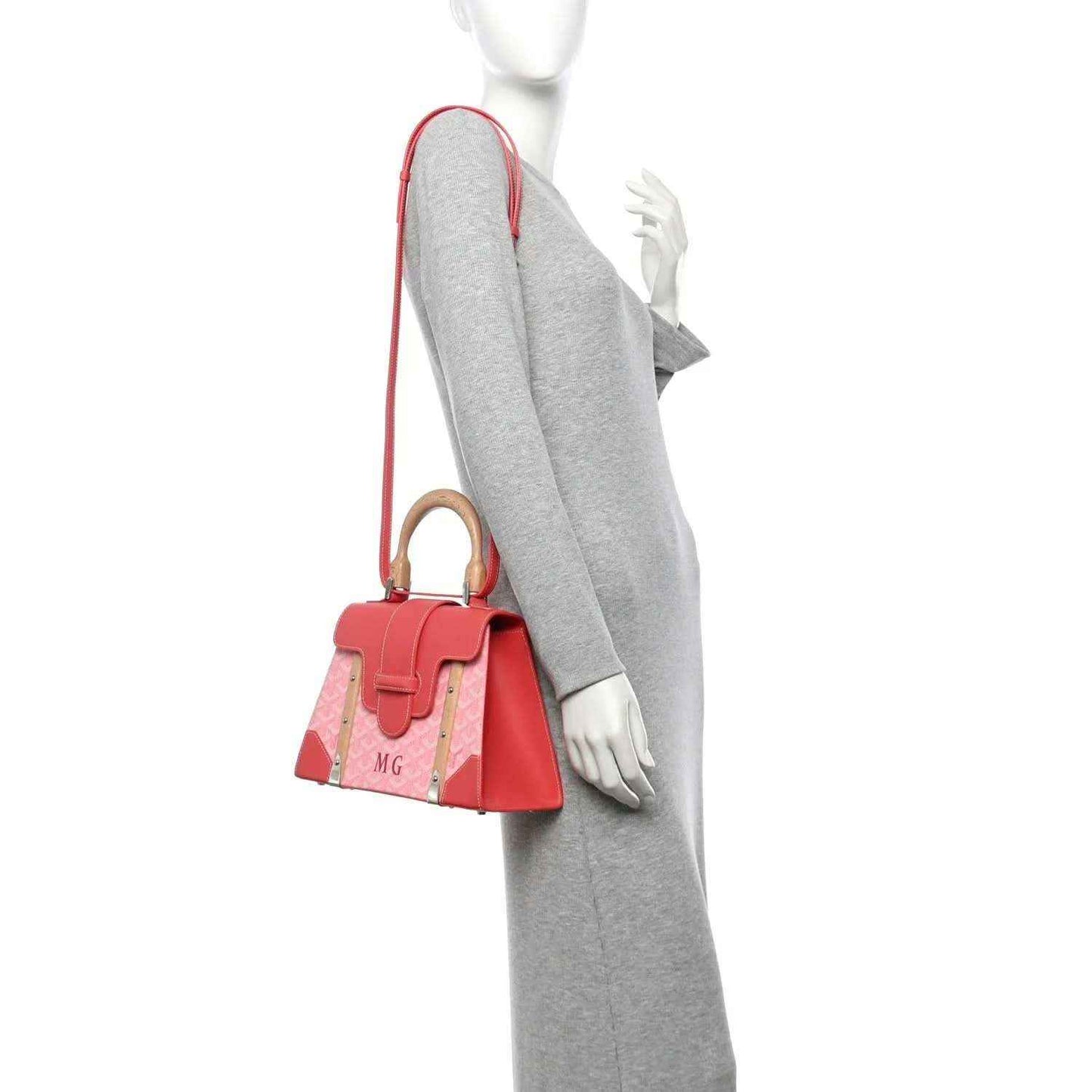 Pink canvas tote with wooden handles and crossbody strap, styled on a model.