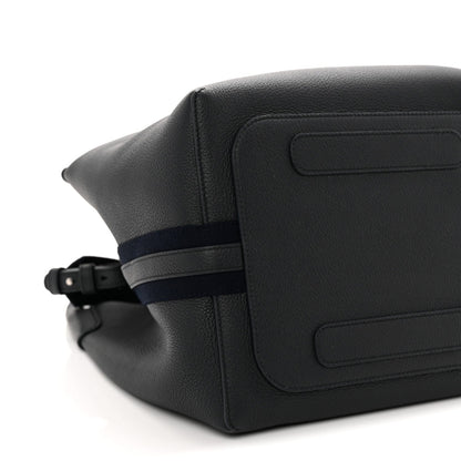 Dark navy leather bag exterior close-up with flap panel and adjustable belt strap
