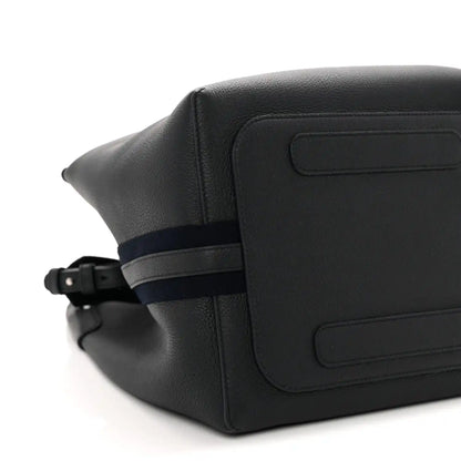 Dark navy leather bag exterior close-up with flap panel and adjustable belt strap
