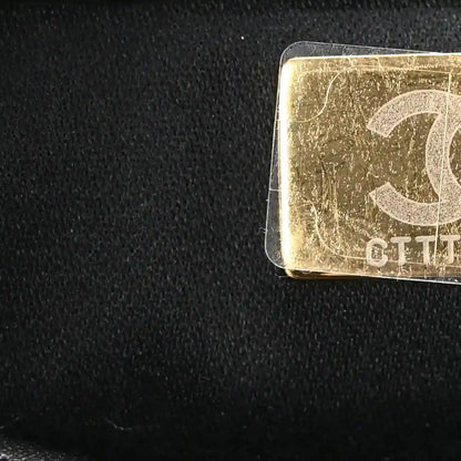 Gold-tone clasp on black leather mini handbag with textured caviar quilting