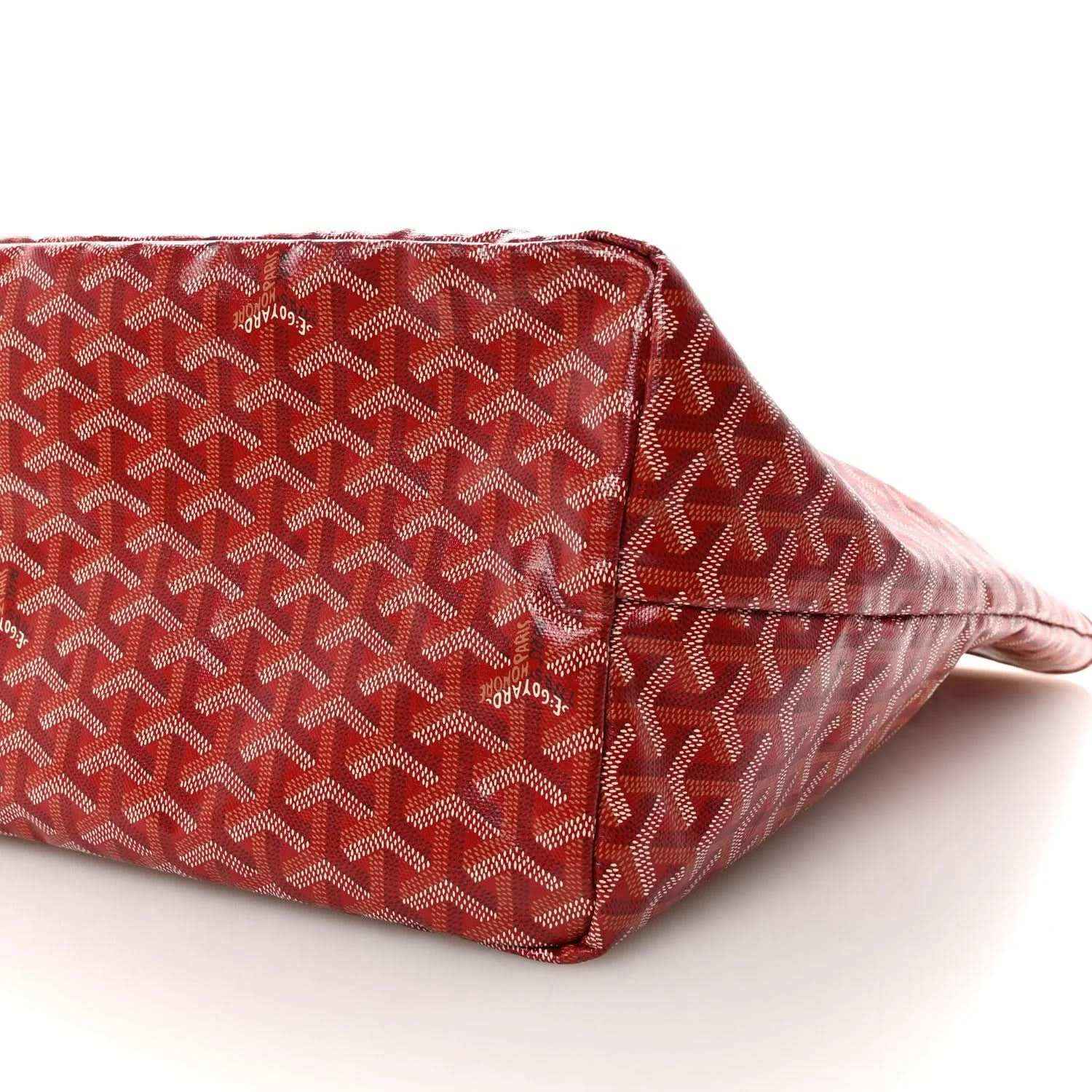 Red Goyardine canvas tote bag side panel with Goyard pattern and corner seam.