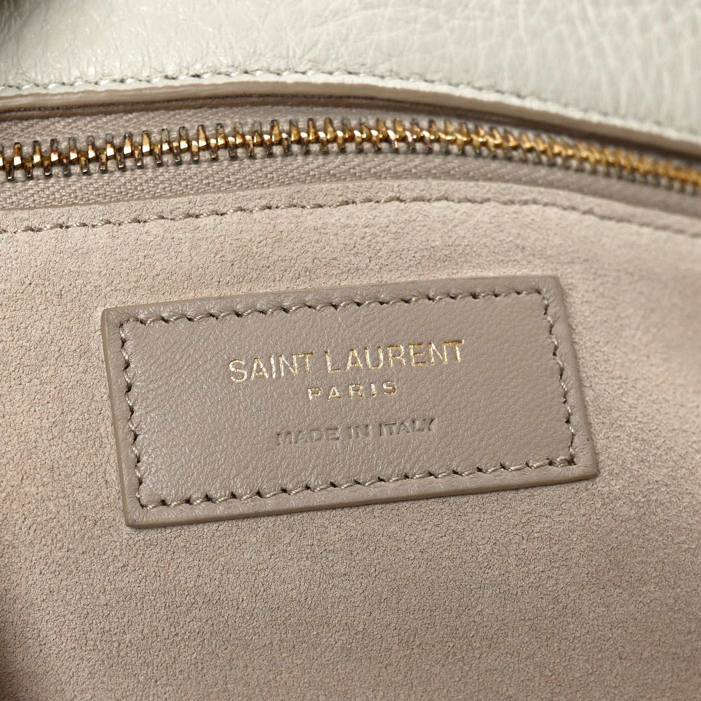 Tote bag interior label with stitched border near the zip opening