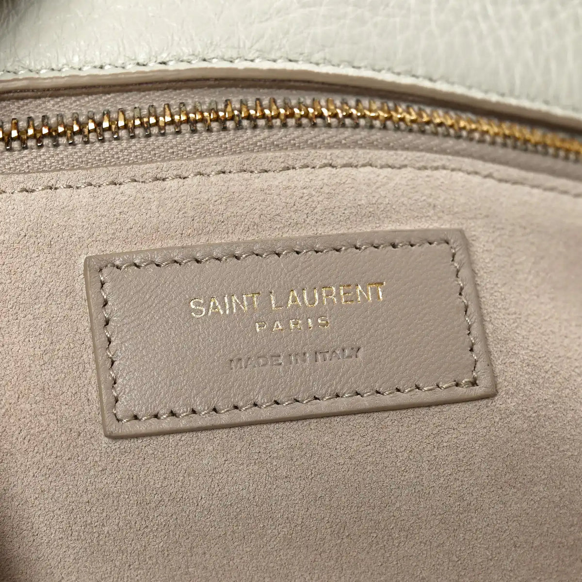 Tote bag interior label with stitched border near the zip opening