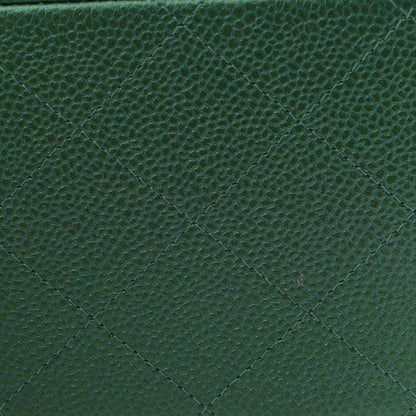 Green quilted caviar leather surface with diamond stitching texture.