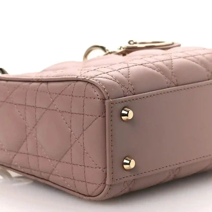 Mini Lady Dior handbag corner close-up in pink quilted leather with gold-tone studs.