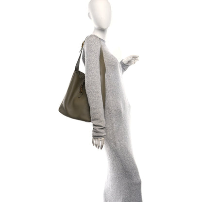 Olive leather hobo bag worn on shoulder by a model