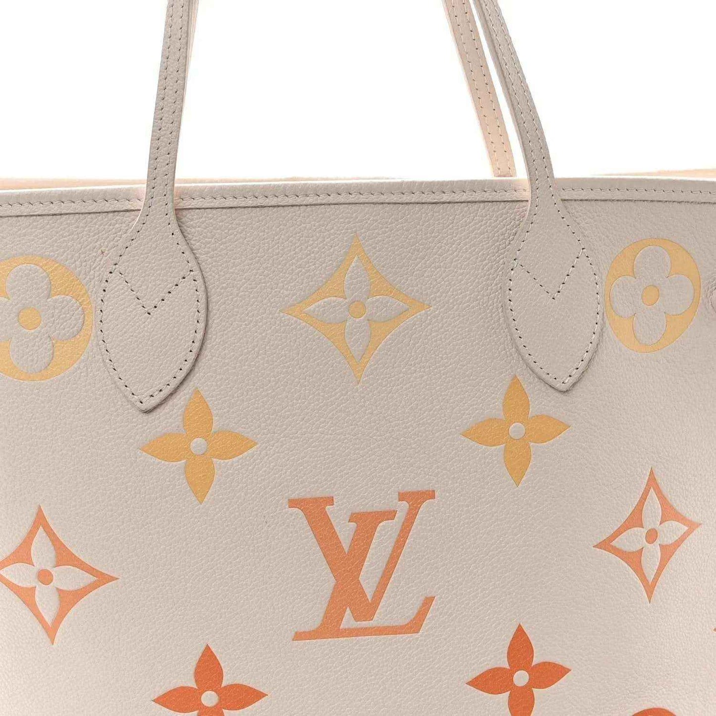 Neutral tote close-up showing monogram pattern and attached leather handle tabs