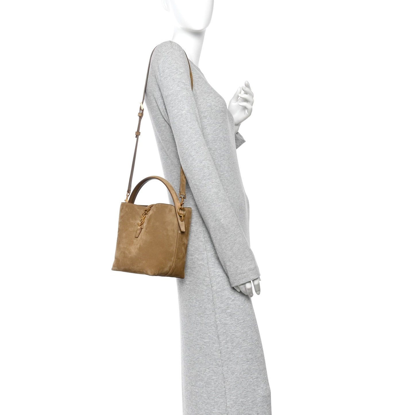 Suede bucket bag on shoulder strap worn with gray dress, golden tan suede