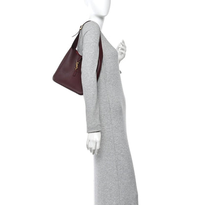 Small hobo bag on model, burgundy smooth calfskin with gold YSL clasp