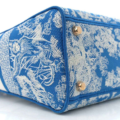 Blue embroidered small bag with snap flap ends and contrast trim around edges.