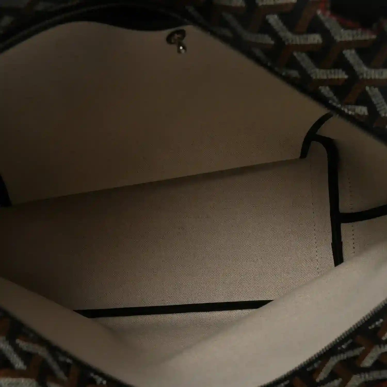 Tote bag interior lining in light fabric with black edging.