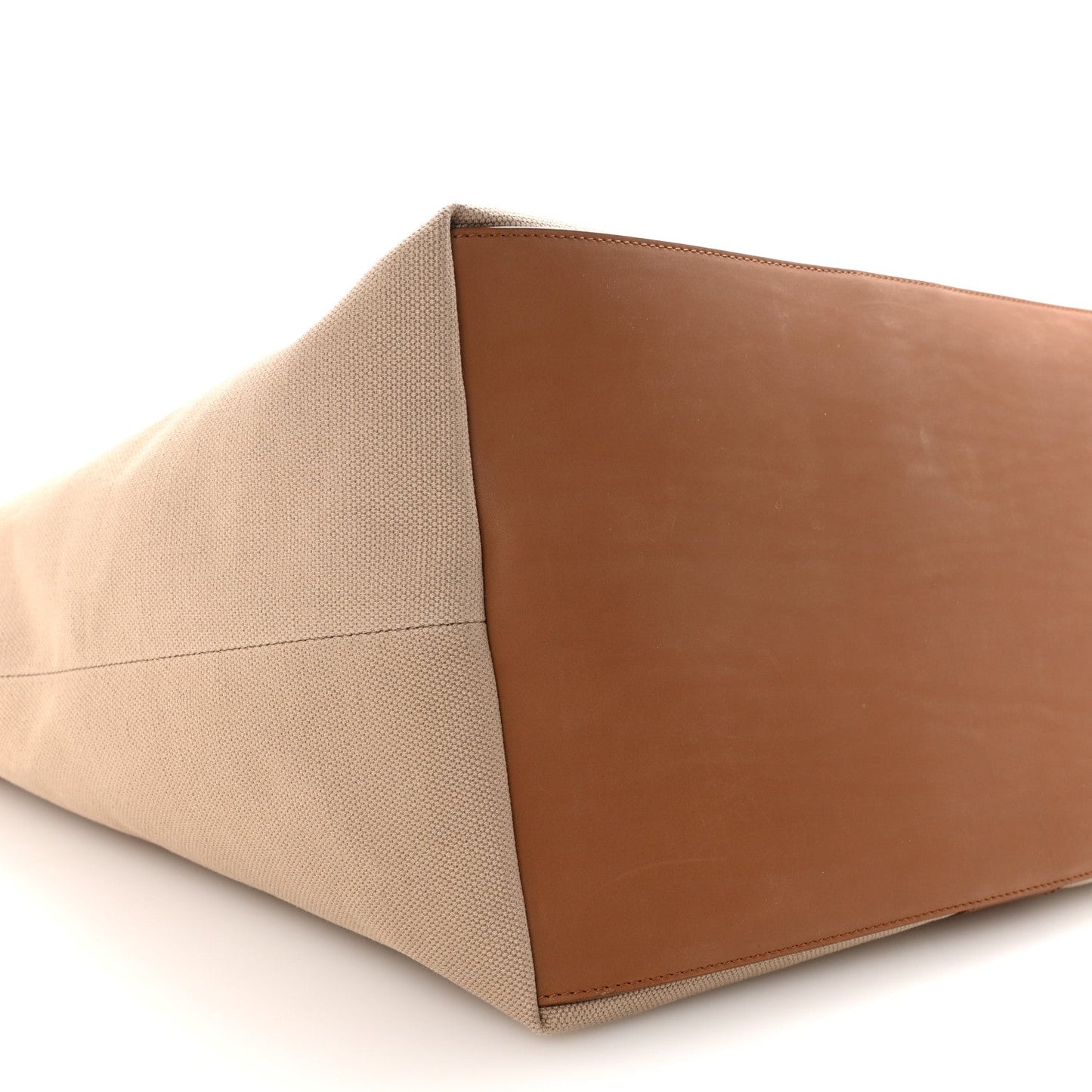 Tan canvas tote base with brown leather panel, close-up angled