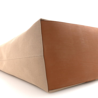 Tan canvas tote base with brown leather panel, close-up angled