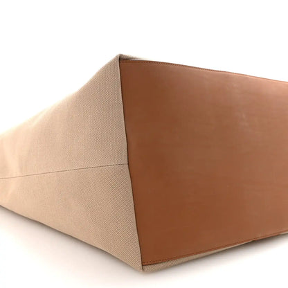 Tan canvas tote base with brown leather panel, close-up angled