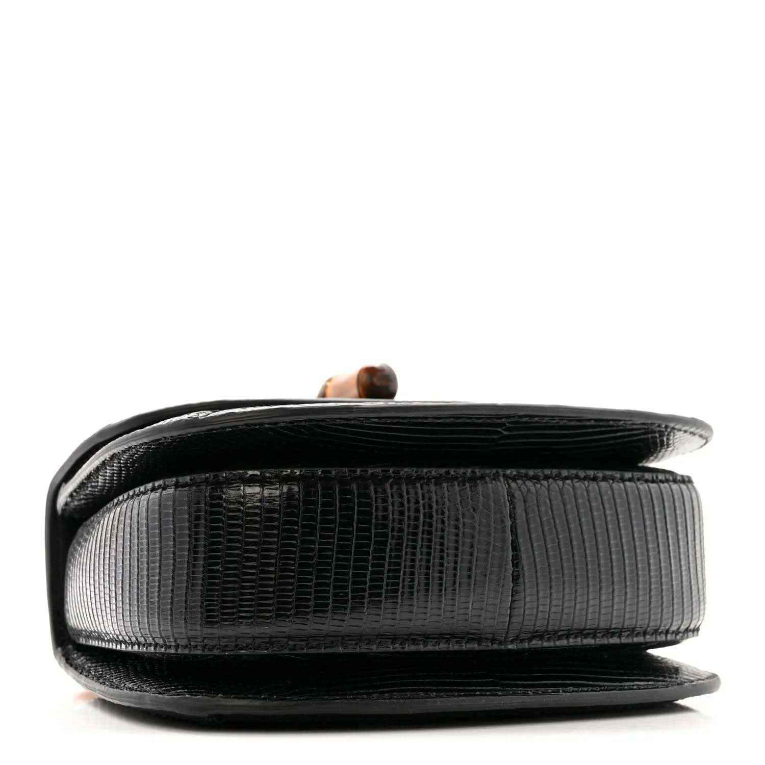 Side view of black mini top handle bag with textured finish and bamboo handle detail
